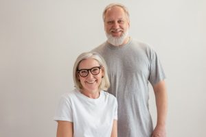 Cheerful senior couple smiling indoors, capturing a warm and happy moment together.